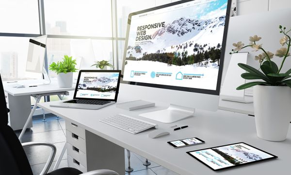 Schreibtisch mit verschiedenen Geräten, Smartphone, PC, Tablet